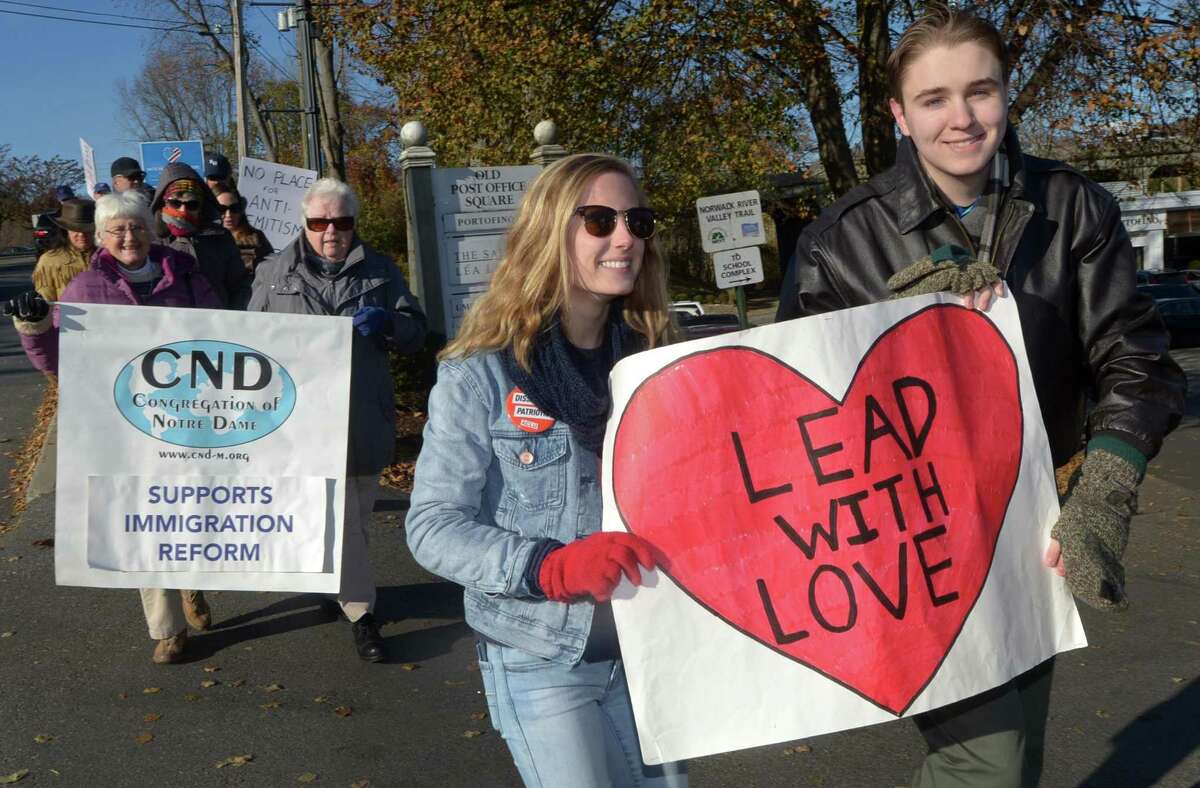 Norwalk High School students and members of the Women's Activist Club, Grace Bracken and Solomon Wozniak, participate in a march against hate and bigotry organized by Scott Milnor and Susan Cutler as it moves through Wilton Center from the Wilton Train Station Saturday, November 11, 2017, in Wilton, Conn. While their specific act of protest is a reaction to the anti-Semitic note found on a sixth-grader?’s locker at Middlebrook, Saturday?’s march is aimed at all acts of intolerance, bigotry and hate.