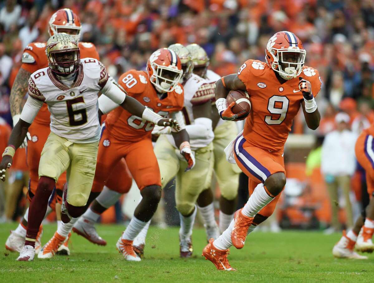 Clemson running back Travis Etienne, right, ran for 97 yards and a pair of touchdowns as the fourth-ranked Tigers nailed down the Atlantic Coast Conference Atlantic Division title with a 31-14 win over Florida State.
