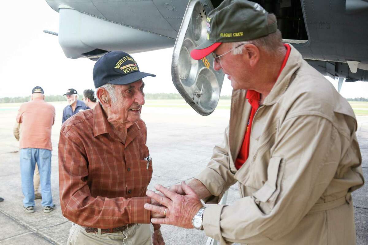World War II veteran James Bivin, 95, left, shakes hands with Per Barsten, of the Texas Raiders, right, exits a B-17 Flying Fortress after going on a flight Saturday, Nov. 12, 2017, at Conroe-North Houston Regional Airport.