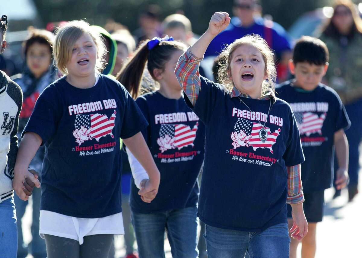 Students from Houser Elementary School cheer as they make their way to Oak Ridge High School for a Veteran's Day celebration event, Friday, Nov. 10, 2017, in Shenandoah.