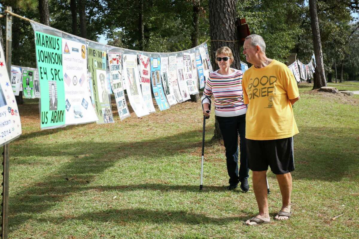 The Woodlands resident John Jordan, a Vietnam War Army veteran, right, browses about 1,200 posters celebrating veterans with his wife Barbara on Friday, Nov. 10, 2017, outside of McCullough Junior High in The Woodlands.