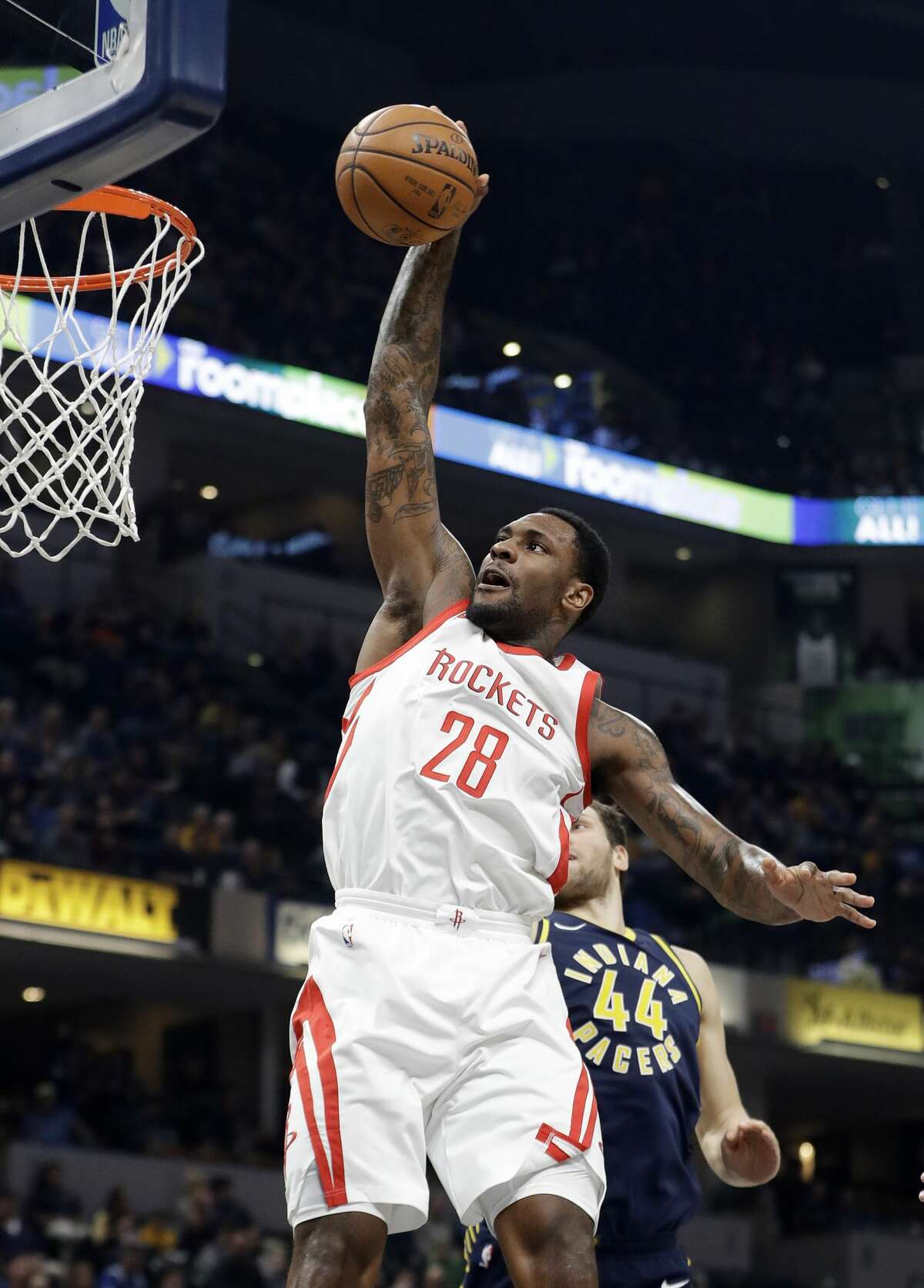 Houston Rockets' Tarik Black (28) dunks against Indiana Pacers' Bojan Bogdanovic (44) during the first half of an NBA basketball game, Sunday, Nov. 12, 2017, in Indianapolis. (AP Photo/Darron Cummings)
