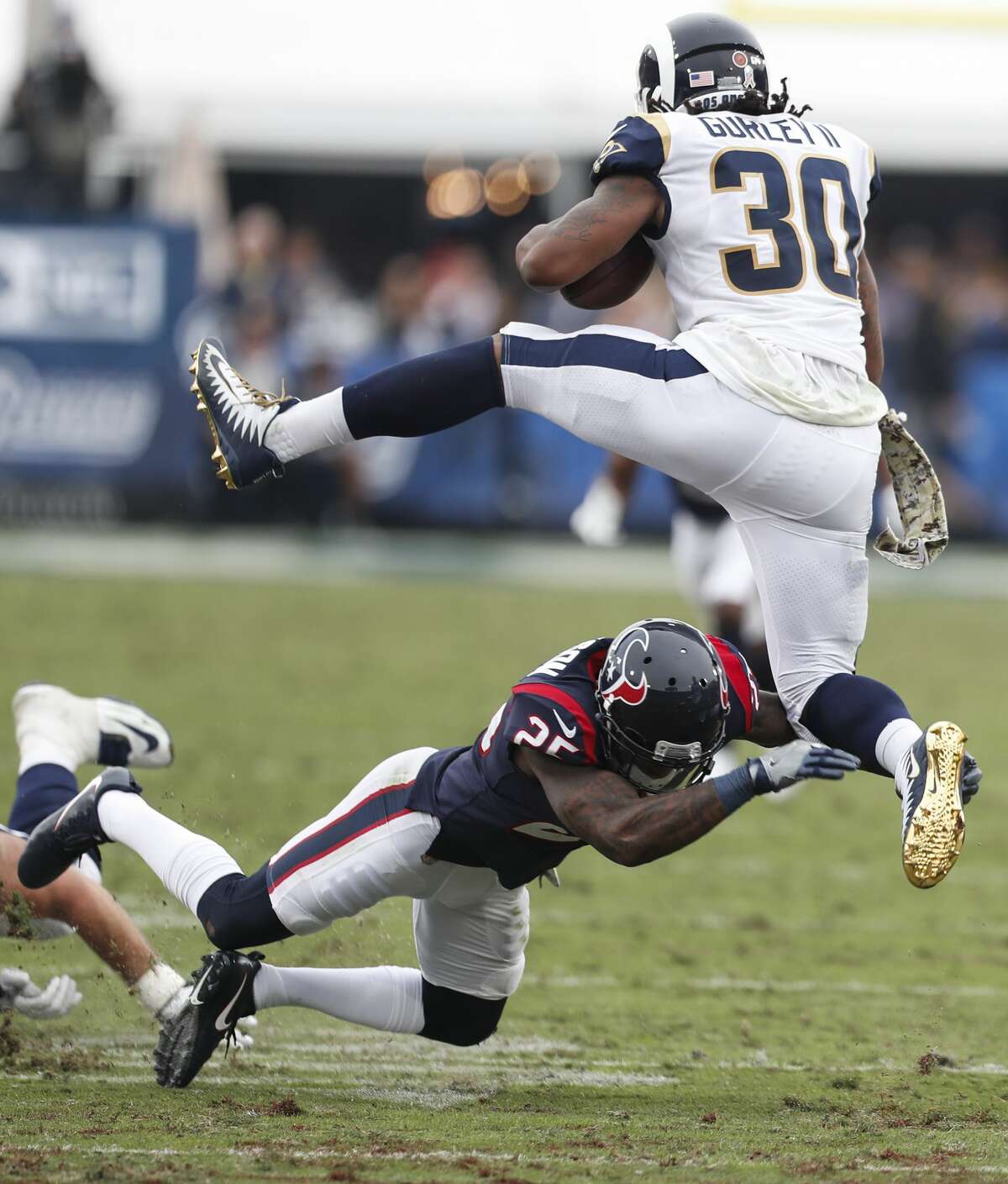 Los Angeles Rams running back Todd Gurley (30) leaps over Houston Texans cornerback Kareem Jackson (25) during the third quarter of an NFL football game at the Los Angeles Memorial Coliseum on Sunday, Nov. 12, 2017, in Los Angeles. ( Brett Coomer / Houston Chronicle )