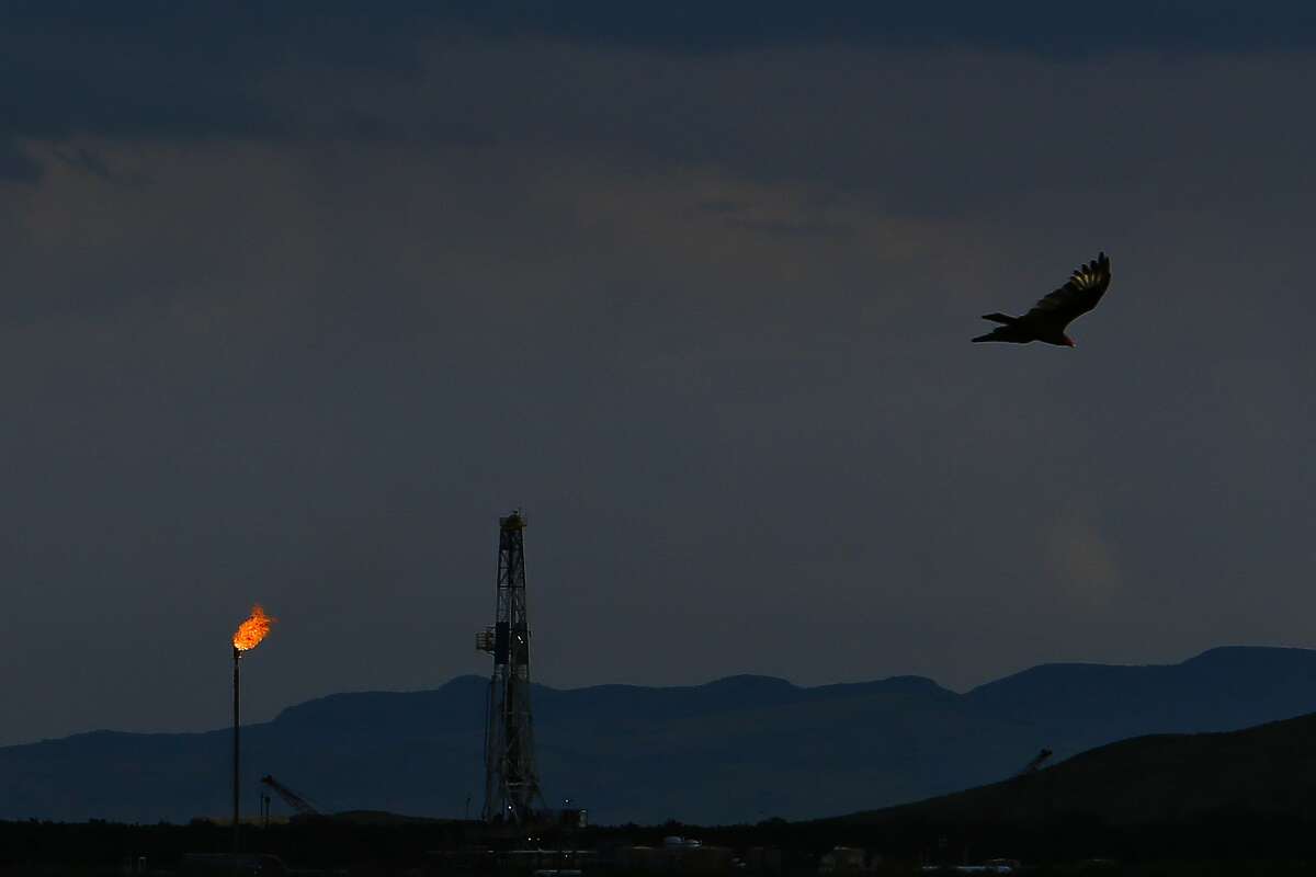 A vulture soars over an Apache Corporation flare and drilling rig north of the Davis Mountains Friday, Sept. 16, 2016 in Balmorhea, TX. Apache Corp. gifted $257,000 to the University of Texas’ McDonald Observatory to help with the prevention of light pollution in dark West Texas skies – which are often used for research.