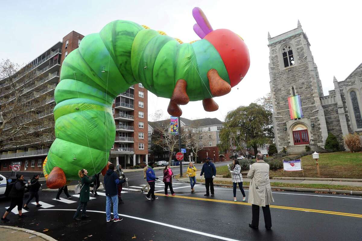 Volunteers practice walking with the 35-foot long inflatable Very Hungry Caterpillar balloon along Walton Place following the 2017 Stamford Downtown Parade Spectacular press conference held in Latham Park in downtown Stamford, Conn. on Monday, Nov. 13, 2017.