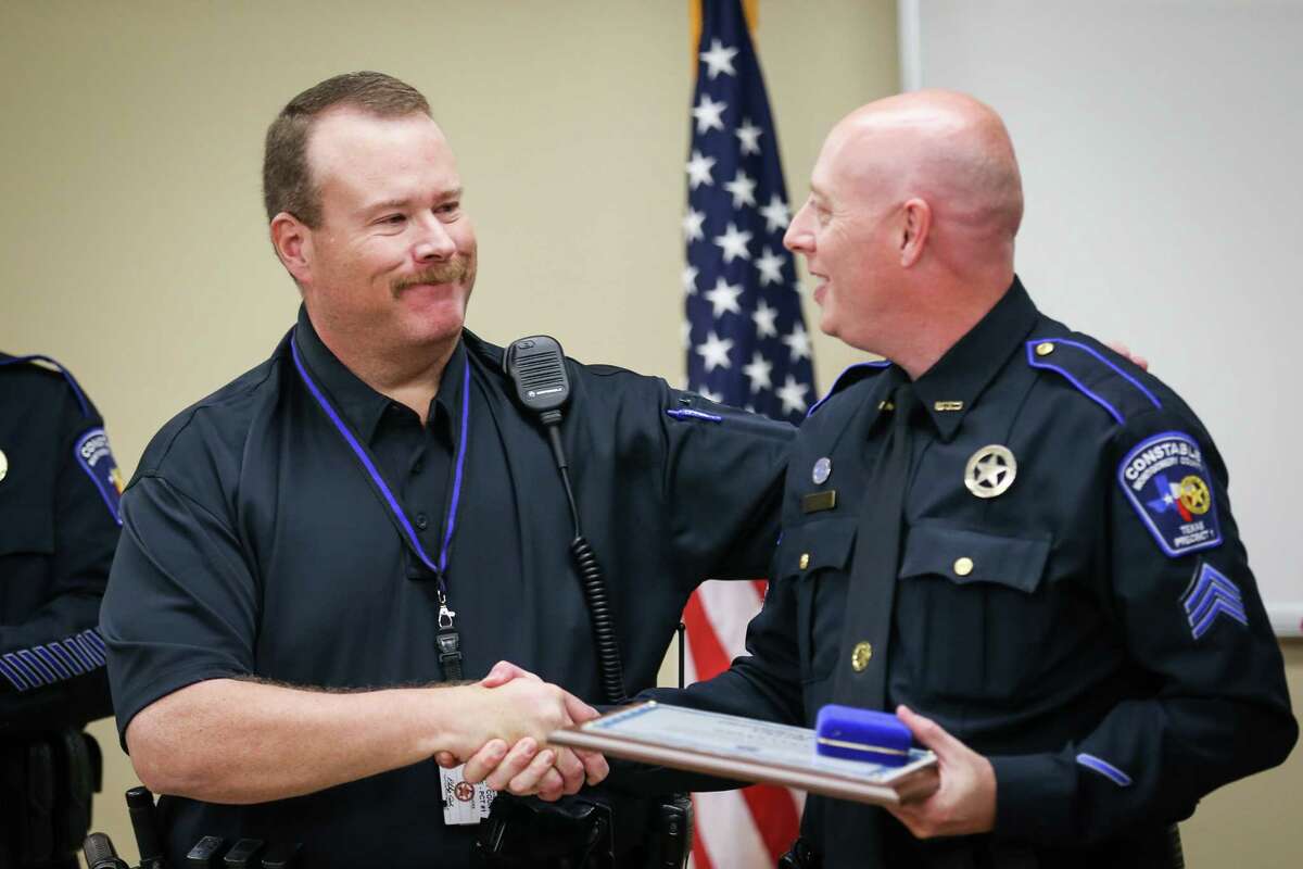 Precinct 1 Constable's deputy Brian Luly, right, shakes hands with then Panorama Village Police officer Billy Beavers, now Precinct 1 Constable's deputy, left, during a certificate of valor presentation on Monday at Precinct 1 Constable's Office.