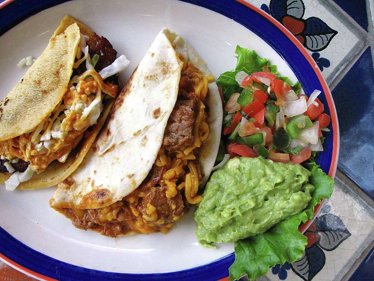 Grilled fish taco on a handmade corn tortilla, left, and a carne guisada taco with cheese on handmade flour from La Margarita.