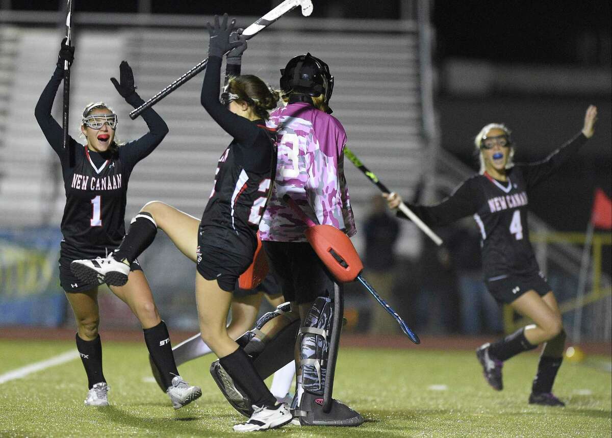 New Canaan Lauren Sturm (1) and Izzy Nesbett (4) react as Marlee Smith, center, celebrates her goal against Branford Tuesday night in a CIAC Class M field hockey semifinals at Trumbull High School. The Rams won, 2-1.