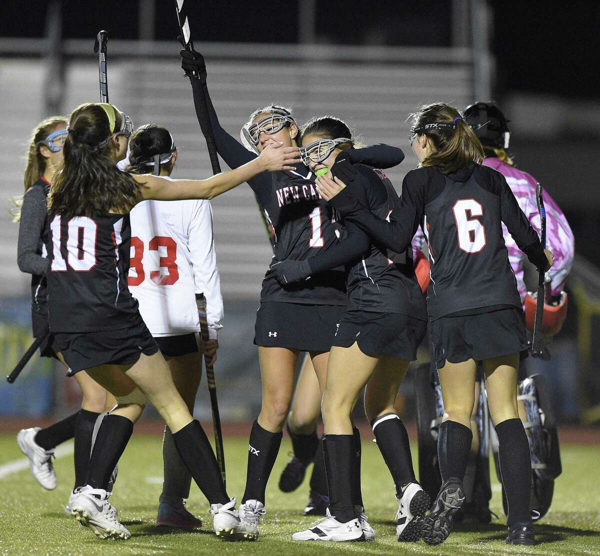 New Canaan Marlee Smith (25), center, is mugged by her teammates as they celebrate her goal against Branford goalie Erica Klarman (83) in a CIAC 2017 State Field Hockey Tournament Class M semifinal game at Trumbull High School in Trumbull, Connecticut on Tuesday, Nov. 14, 2017. New Canaan defeated Branford 2-1.