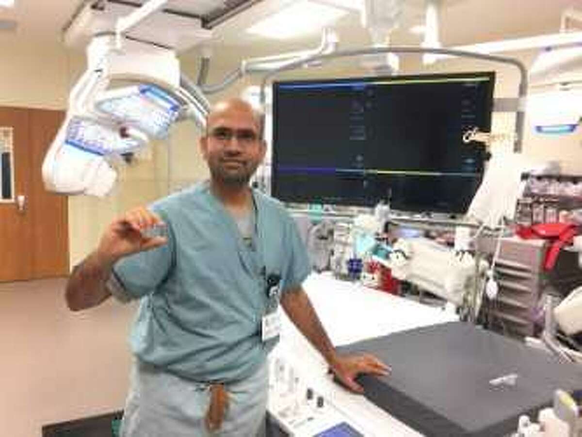 Dr. Rajesh Venkataraman holds the world's smallest pacemaker, which is the size of a vitamin, in the cath lab at Houston Methodist The Woodlands Hospital.