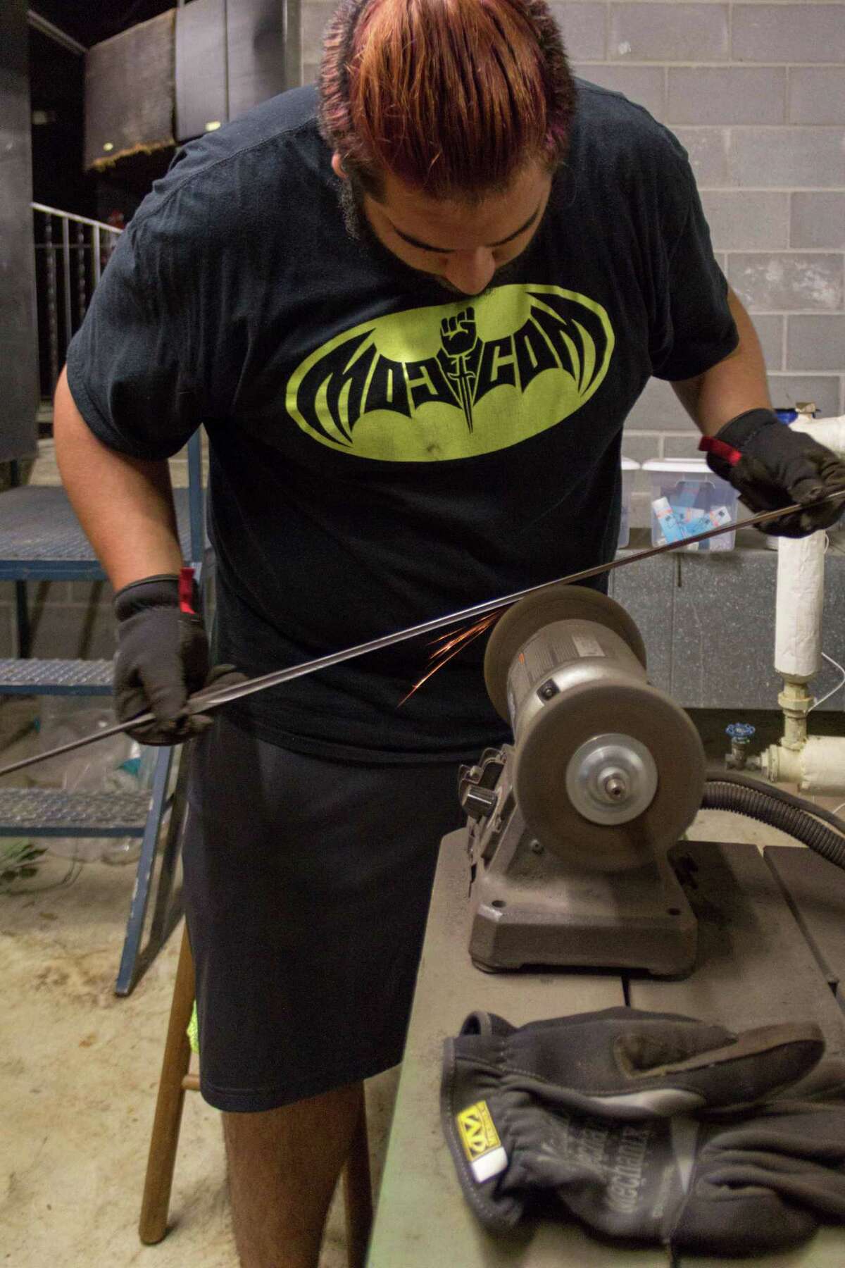 Restoring Alley Theatre's Harvey-damaged weapons was an assembly line process in which College of the Mainland students ground and scraped away rust from the props. Tyler Fayad of Pasadena uses as brush wheel to clean away rust.
