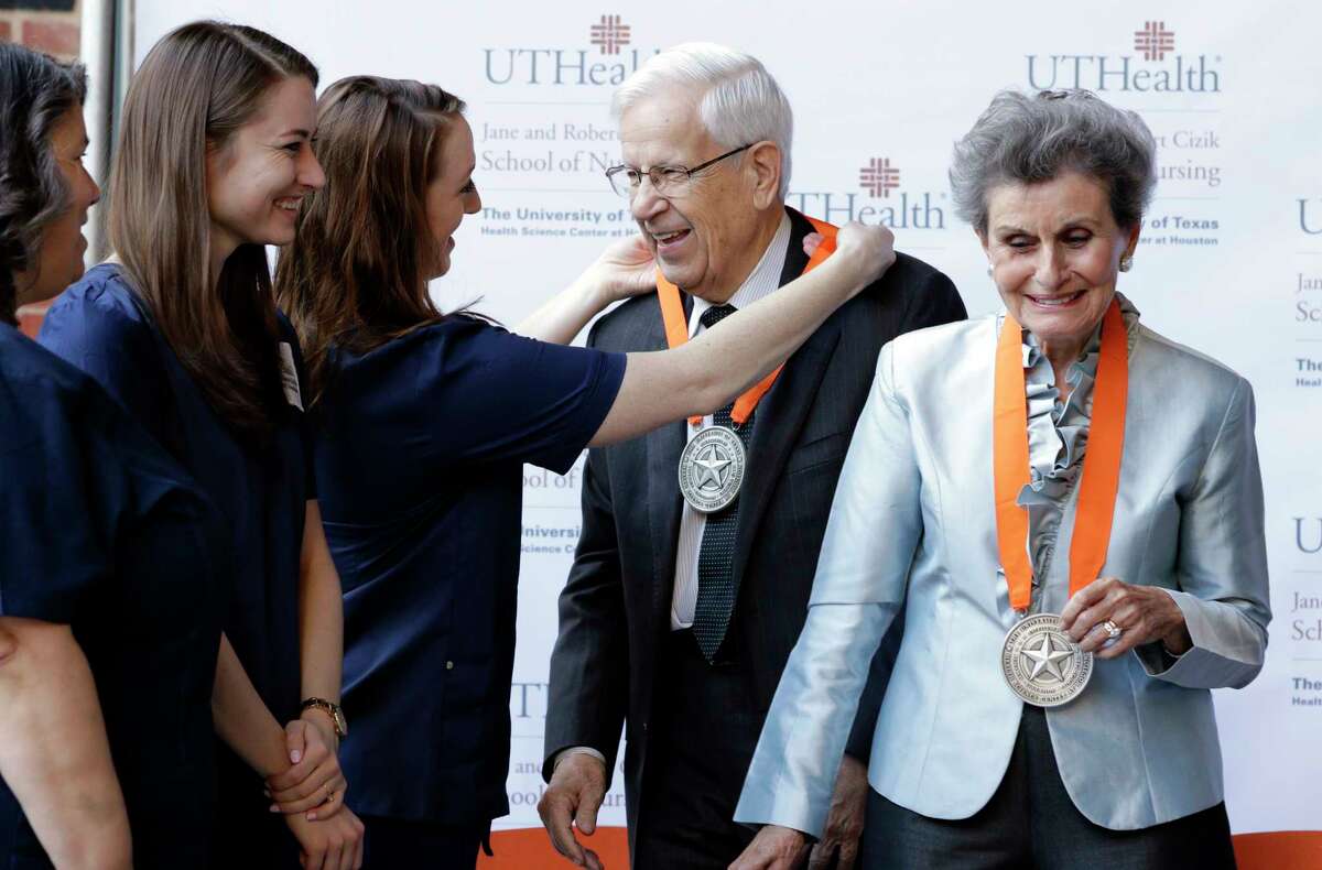 Nursing students ﻿Jennifer Valeasquez, from left, Emily Marso and Krista Robinson give medals to Robert and Jane Cizik﻿ for their $25 million donation.