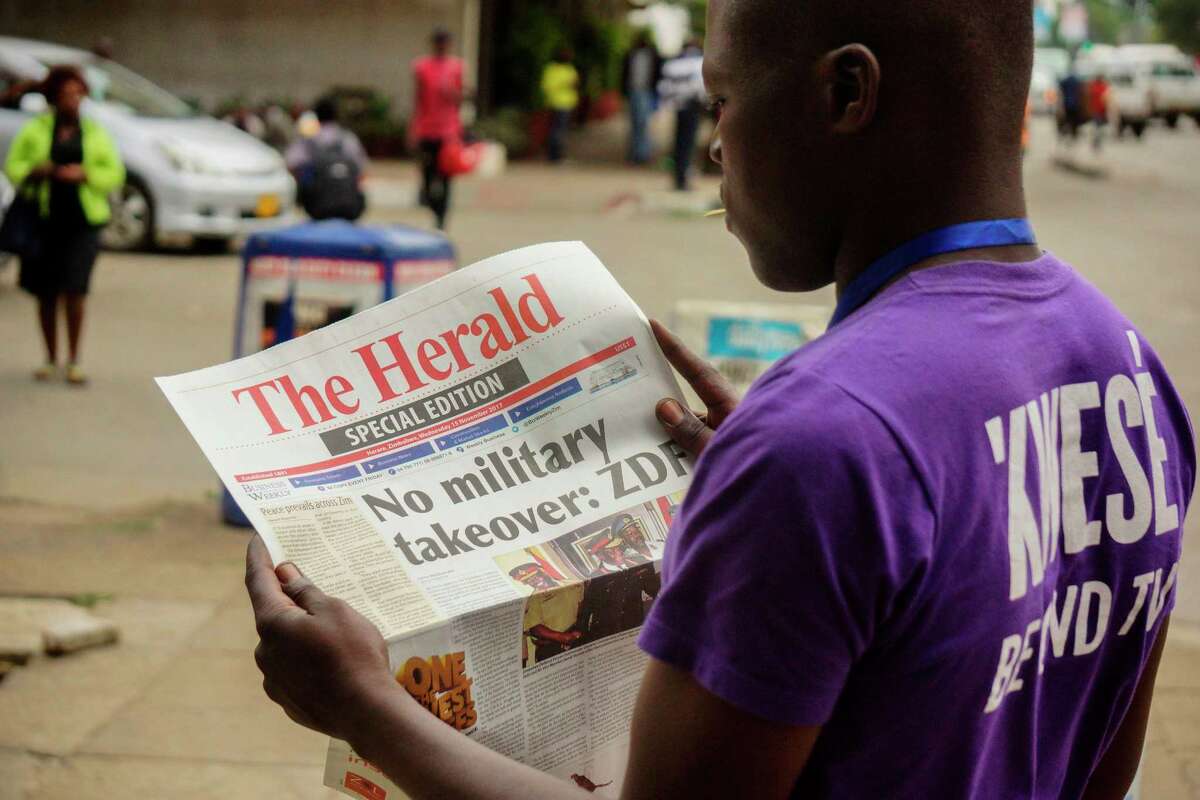 A man reads the front page of a special edition of The Herald newspaper about the crisis in Zimbabwe on November 15, 2017 in Harare. Zimbabwe's military was in control of the country today as the President said he was under house arrest, although generals denied staging a coup. Mugabe's decades-long grip on power appeared to be fading as military vehicles blocked roads outside the parliament in Harare and senior soldiers delivered a late-night television address to the nation. / AFP PHOTO / --/AFP/Getty Images