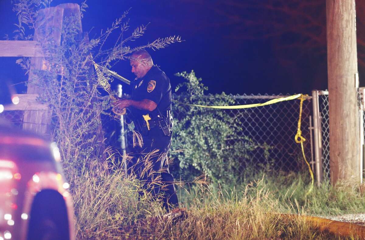 Bexar County Sheriff's Office deputy puts up crime scene tape as fire fighters respond to a structure fire in South Bexar County near Von Ormy on Wednesday, Nov. 15, 2017. Around 9 p.m. neighbors heard screaming and signs of a fire. Initial reports indicated that people were trapped in the structure. As of 10:41 p.m. fire fighters were still on the scene. (Kin Man Hui/San Antonio Express-News)