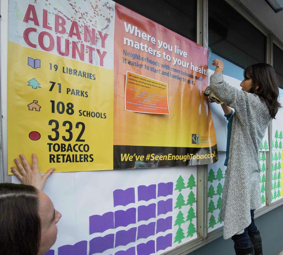Jeanie Orr, right and Cara Zampi of the Capital District Tobacco-Free Communities put up an interactive map that reveals the problem of tobacco marketing in great capital district on the front of the Boys and Girls Club Thursday Nov. 16, 2017 in Albany, N.Y. (Skip Dickstein/ Times Union)