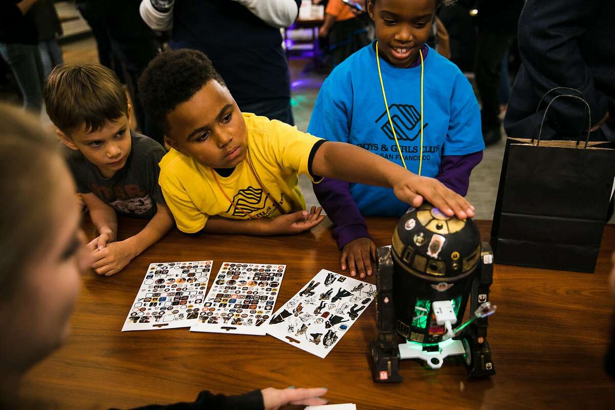 Theo Turnipseed 8, center, touches the ILMxLAB's droid as kids from the Booker T. Washington Community Center, Black Girls CODE, Boys & Girls Club and the YMCA judge tech-companies Star Wars-style droids during the Droidathon event at Lucasfilm Digital Arts Center in San Francisco, Calif. Wednesday, November 15, 2017.