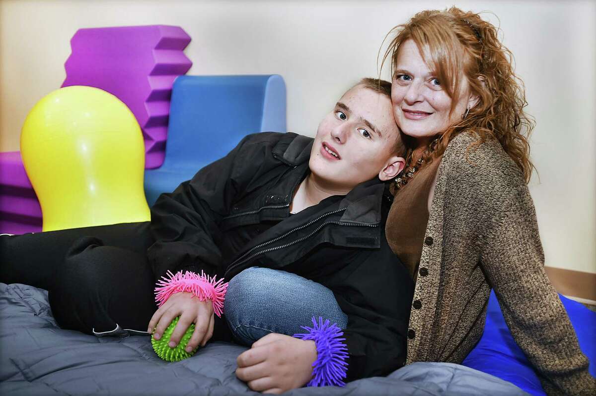 Cheryl D’Argento of North Branford and her 13-year-old son Michael Girardi are seen in the occupational therapy / physical therapy room at the grand opening of the Clifford Beers Marne Street Clinic in Hamden Thursday.