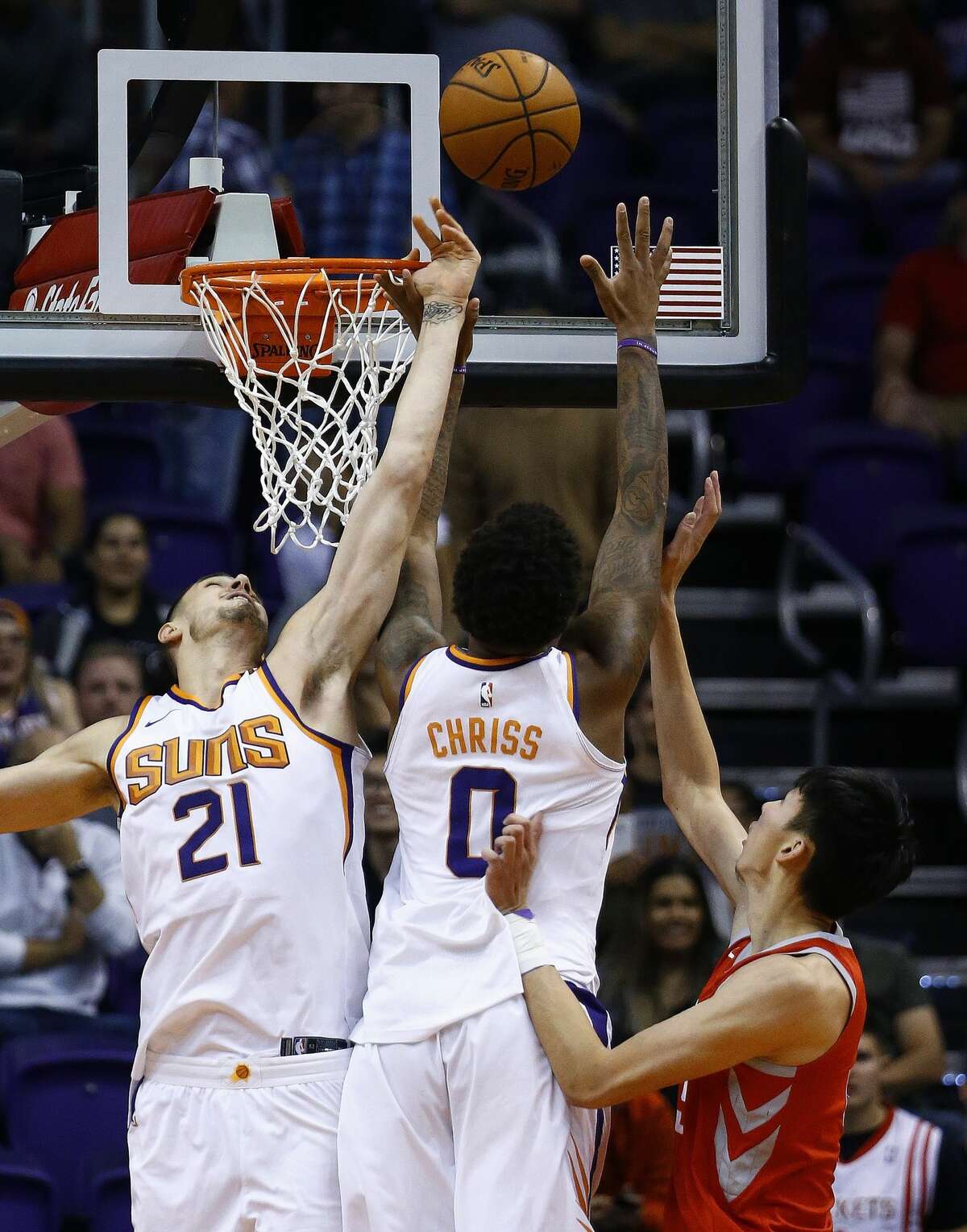 Phoenix Suns center Alex Len (21) and forward Marquese Chriss (0) block the shot of Houston Rockets forward Zhou Qi, right, of China, during the second half of an NBA basketball game Thursday, Nov. 16, 2017, in Phoenix. The Rockets defeated the Suns 142-116. (AP Photo/Ross D. Franklin)