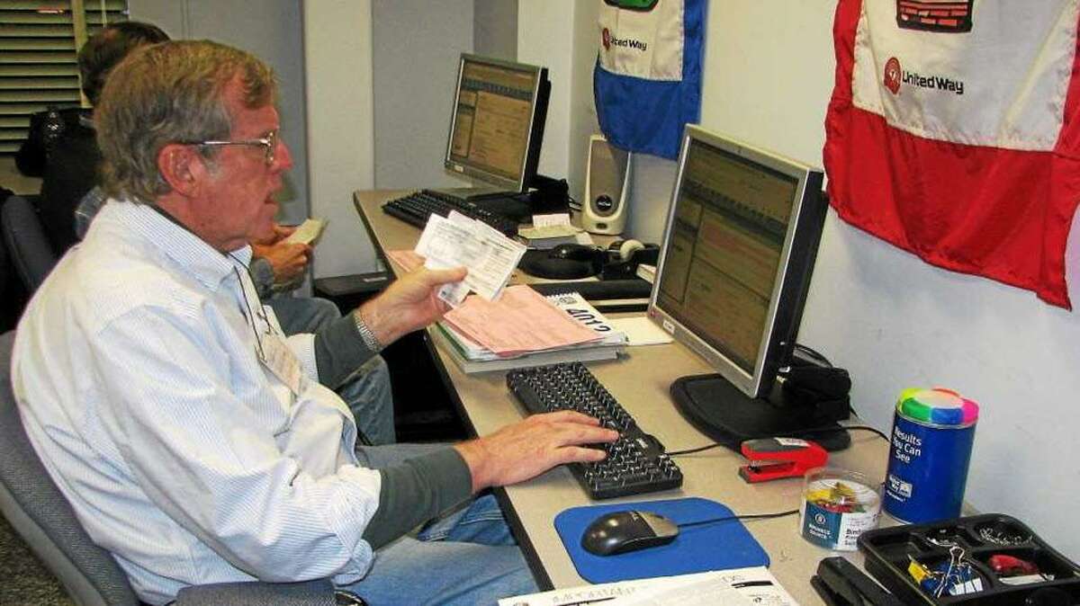 Volunteer David Morgan assists a client with taxes at the VITA site at the Middlesex United Way office in Middletown.