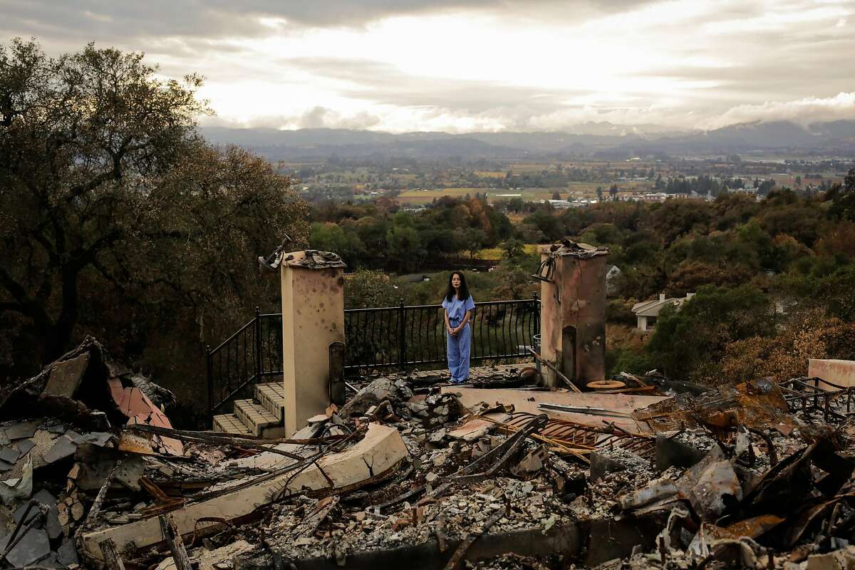 Dr. Stephanie Huang stands for a portrait at her home which was destroyed in the Tubbs fire in the Fountain Grove neighborhood of Santa Rosa, Calif., on Thursday, Nov. 16, 2017. Stephanie has still not bought herself new clothes and has been wearing her medical scrubs everyday since the fire.