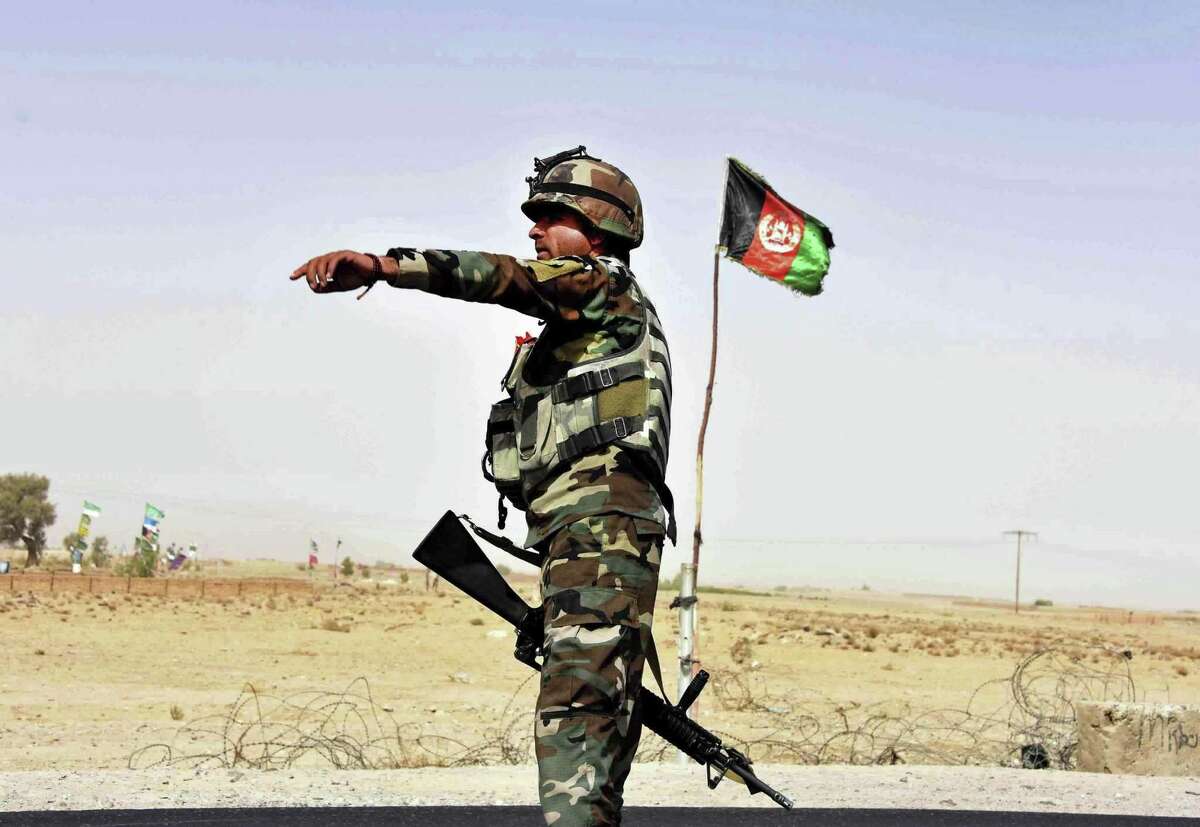 An Afghan National Army soldier directs a vehicle to stop at a checkpoint last month in Kandahar, Afghanistan. Amid unrelenting violence, more than 150 Afghan military personnel sent to the U.S. for training since 2005 have gone AWOL, including 60 from Joint Base San Antonio.