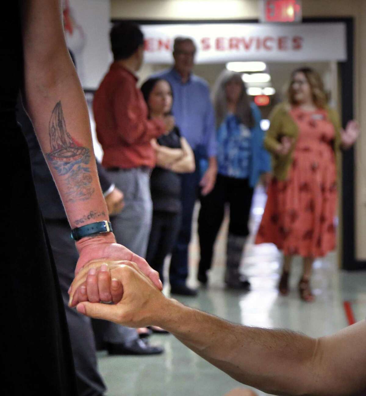 A former patient holds hands with Andrea Moutria-Nino, Director of Prevention at an AIDS Foundation HIV outpatient clinic on the East Side in November. The former patient is doing great.