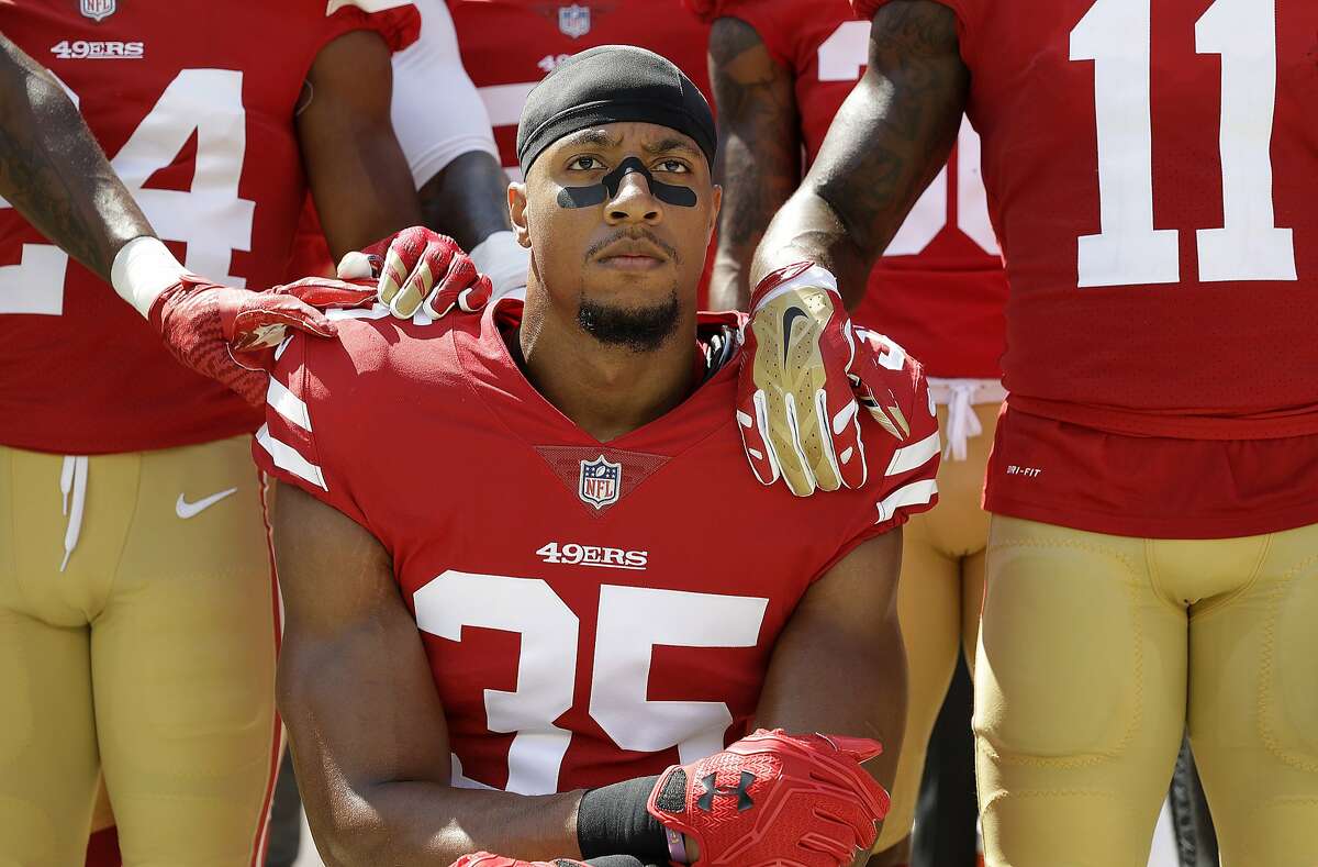 San Francisco 49ers safety Eric Reid (35) kneels in front of teammates during the playing of the national anthem before an NFL football game against the Carolina Panthers, in Santa Clara, Calif.