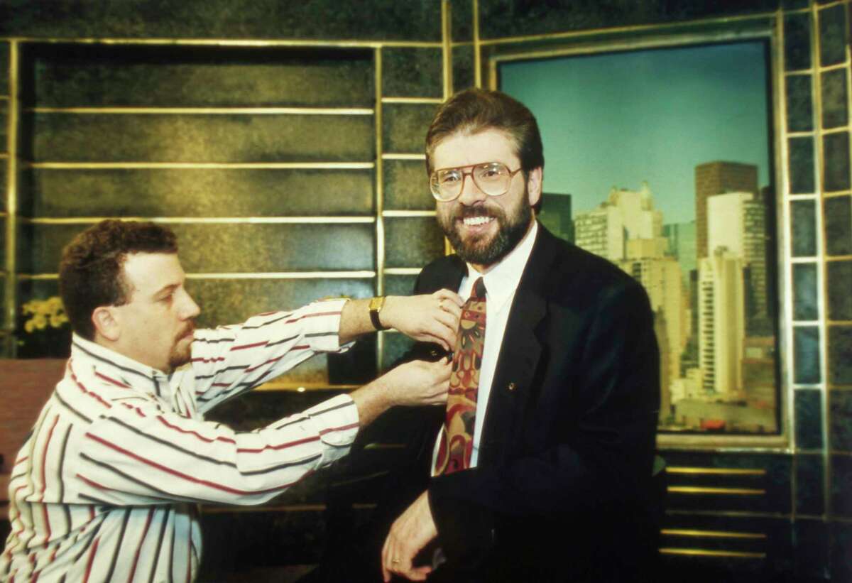 FILE - In this Monday, Jan. 31, 1994 file photo, Gerry Adams, right, president of Sinn Fein, is assisted by engineer Tony Mandile as Adams gets ready for an interview with talk show host Larry King at CNN studios in New York City. Gerry Adams has announced that he plans to step down as leader of Sinn Fein next year after heading the party for over 30 years. Adams said in a speech at the party's annual conference in Dublin on Saturday, Nov. 18, 2017 that he will not stand for the next Irish parliamentary election.(AP Photo/Chrystyna Czajkowsky,file)