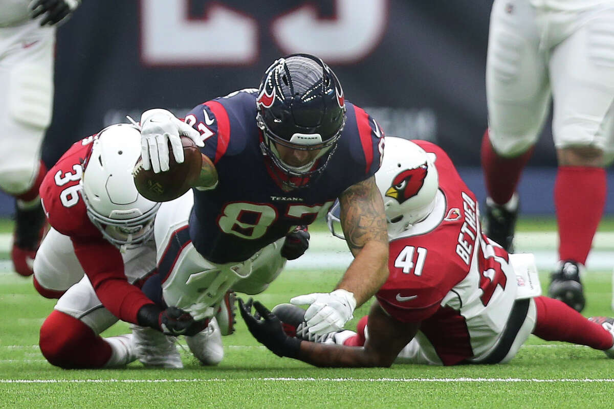 Houston Texans tight end C.J. Fiedorowicz (87) stretches to make a down while Arizona Cardinals players afety Budda Baker (36) and Antoine Bethea (41) tackle him during the first quarter of a NFL game at NRG Stadium on Sunday, Nov. 19, 2017, in Houston.
