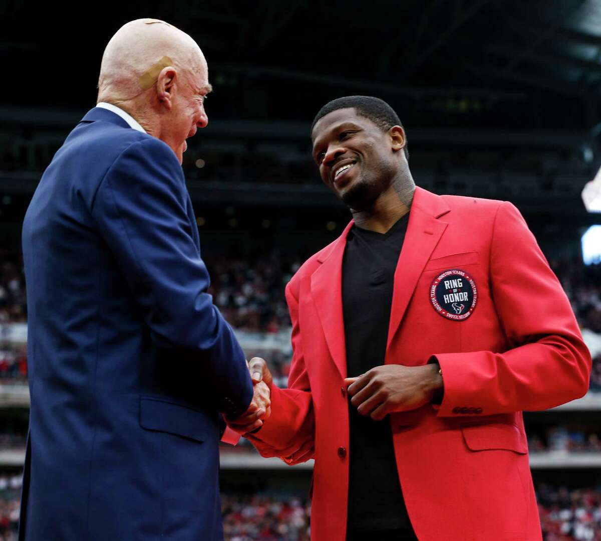 Houston Texans owner Bob McNair shankes hands with former Texans wide receiver Andre Johnson waves to the fans as he is honored as the first Texans player in the Ring of Honor during the halftime celebration at NRG Stadium on Sunday, Nov. 19, 2017, in Houston.
