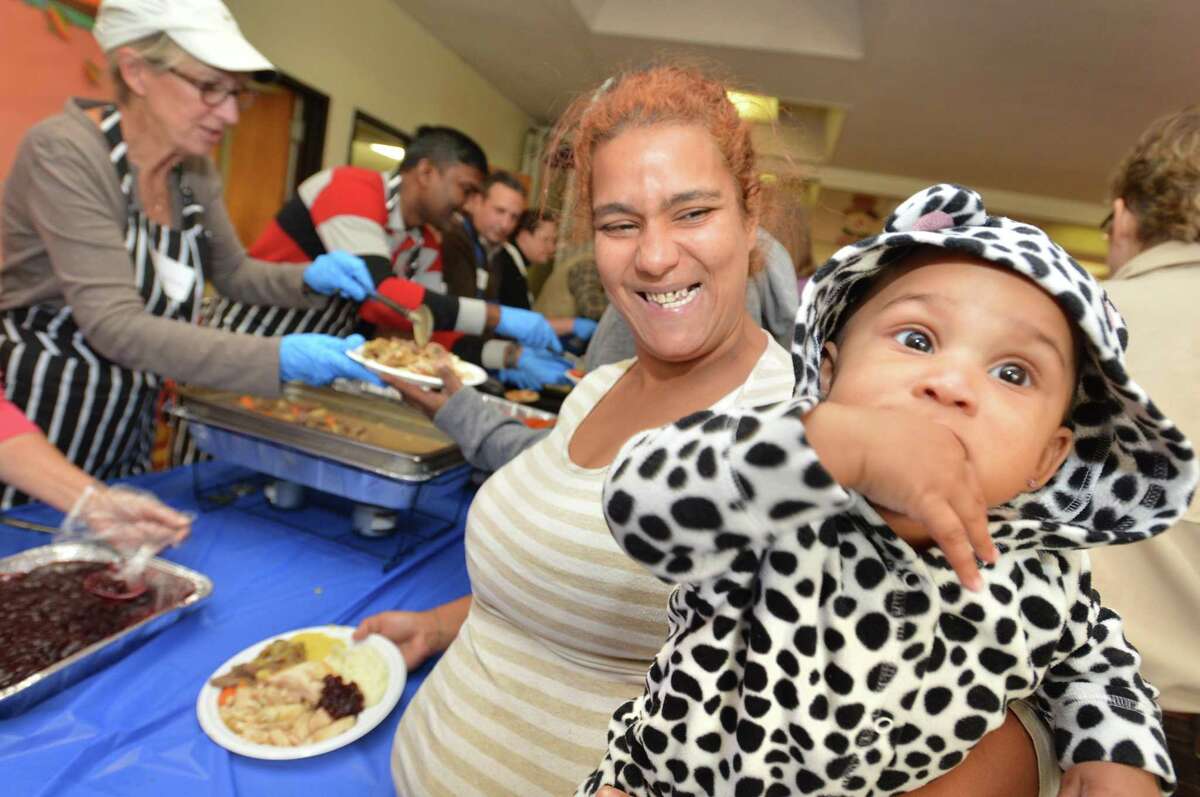 Alexia Morales holds her 8-month-old daughter Cataleya as she and her family fill their plates with turkey and all the trimmings at the18th Annual Community Thanksgiving Luncheon for the public. Through the generosity of Cornerstone Community Church, hundreds were treated to hot turkey, stuffing, potatoes, corn, cranberry sauce, gravy and much more, plus pumpkin and apple pie for desert on Sunday November 19, 2017 in Norwalk Conn.