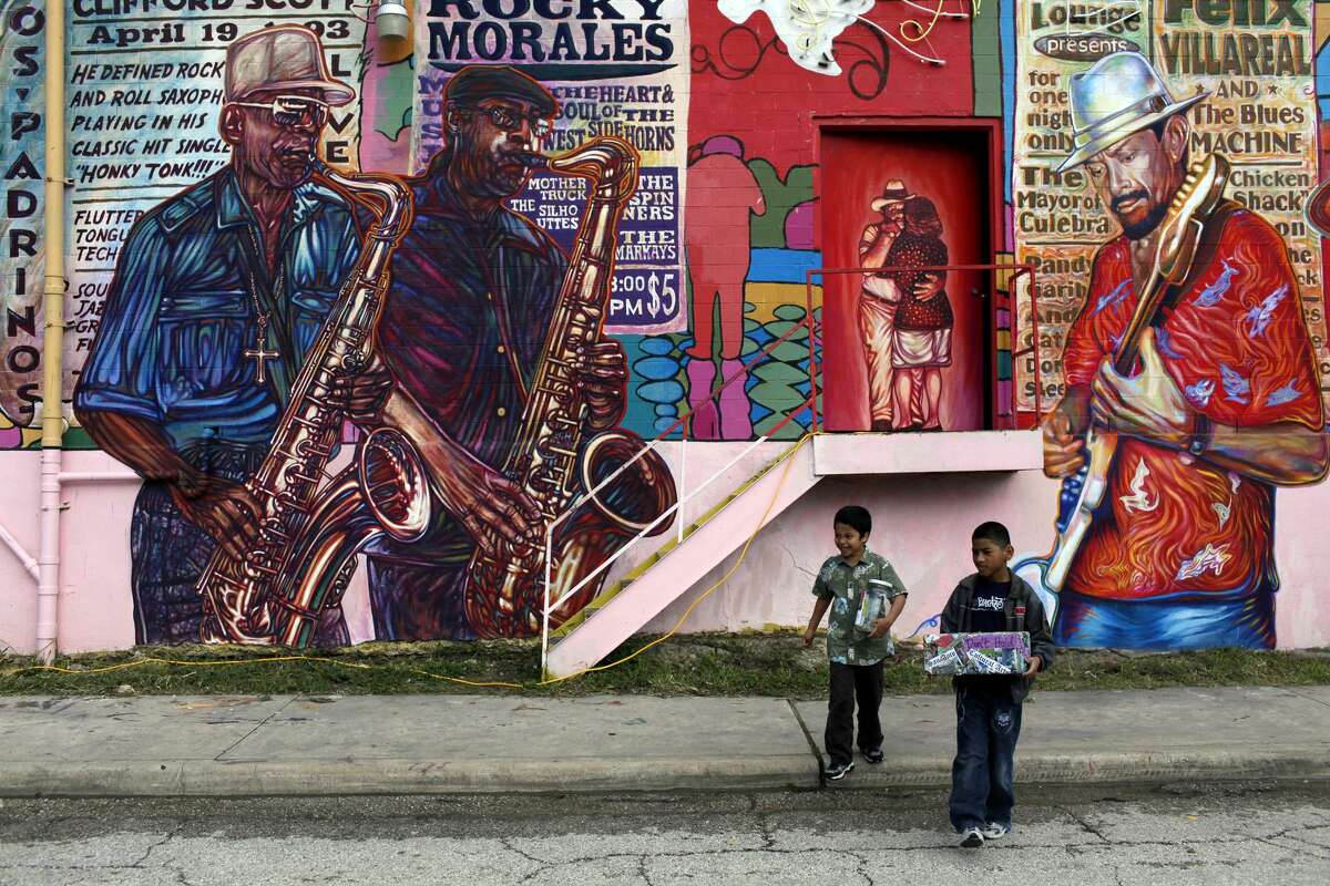 D.J. Vela (left), 6, and Jeremiah Gonzalez, 9, collect donations for San Anto Cultural Arts during the community blessing for the mural “La Musica de San Anto” in 2009.