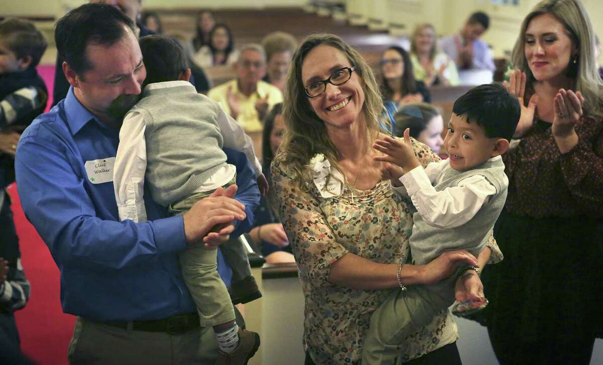 Karen Walker (center) holds her newly adopted son, 19-month-old Antonio Walker, while her husband, Clint Walker (left), holds 3-year-old Jose Walker. Onlookers clapped after the boys’ adoptions were announced at a Texas Department of Family and Protective Services adoption day event at the First Presbyterian Church in Seguin on Monday. At right is Jordan Underwood, Karen’s niece.