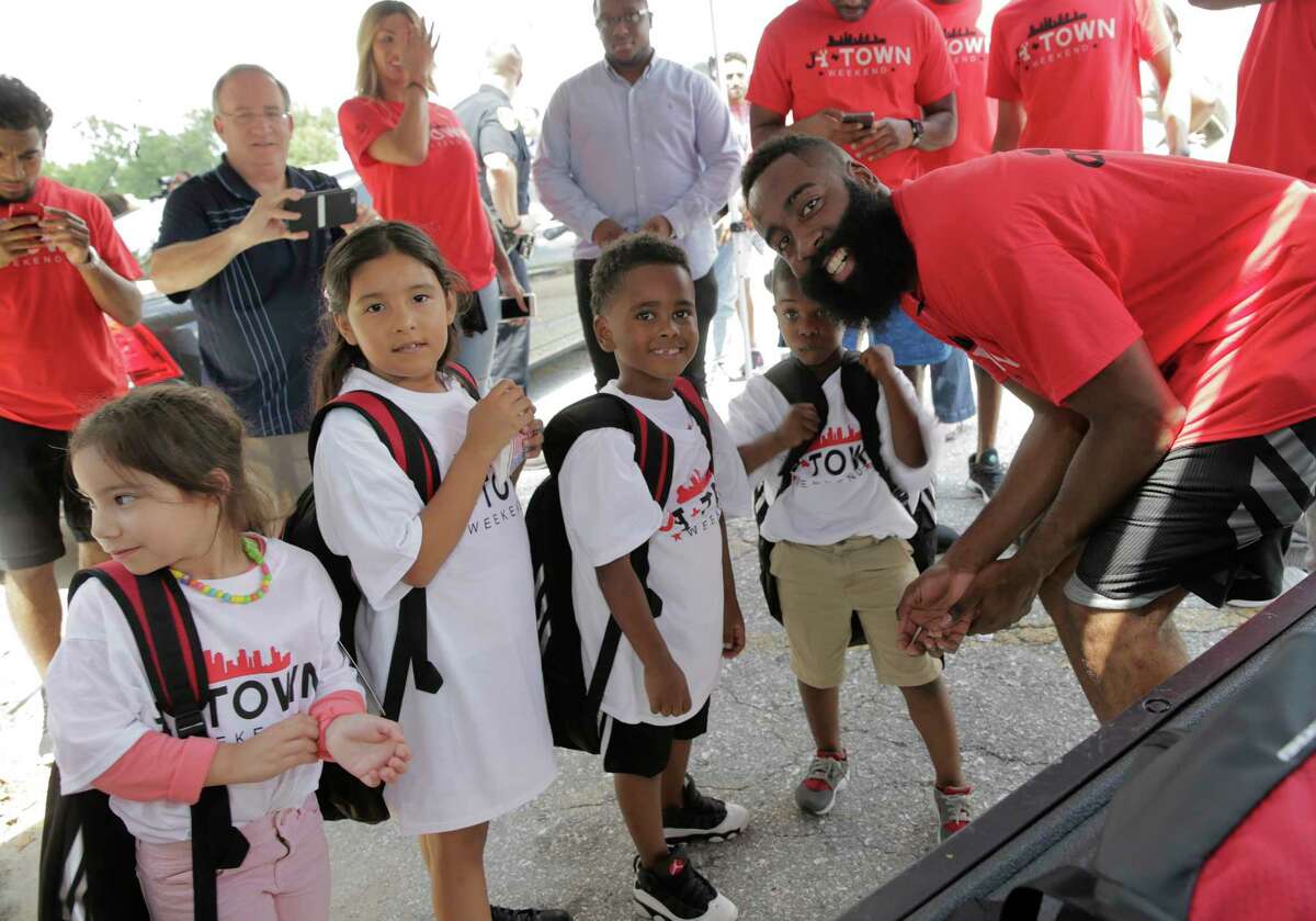 James Harden poses for a photo with some young recipients of backpacks and school supplies on Friday, Aug. 18, 2017, in Houston. ( Elizabeth Conley / Houston Chronicle )