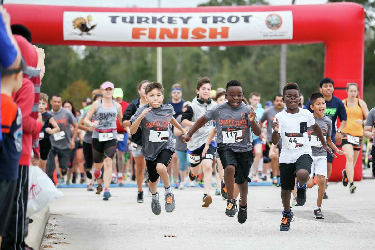 Participants in the Turkey Trot event take off from the starting line on Friday at Carl Barton Jr. Park.