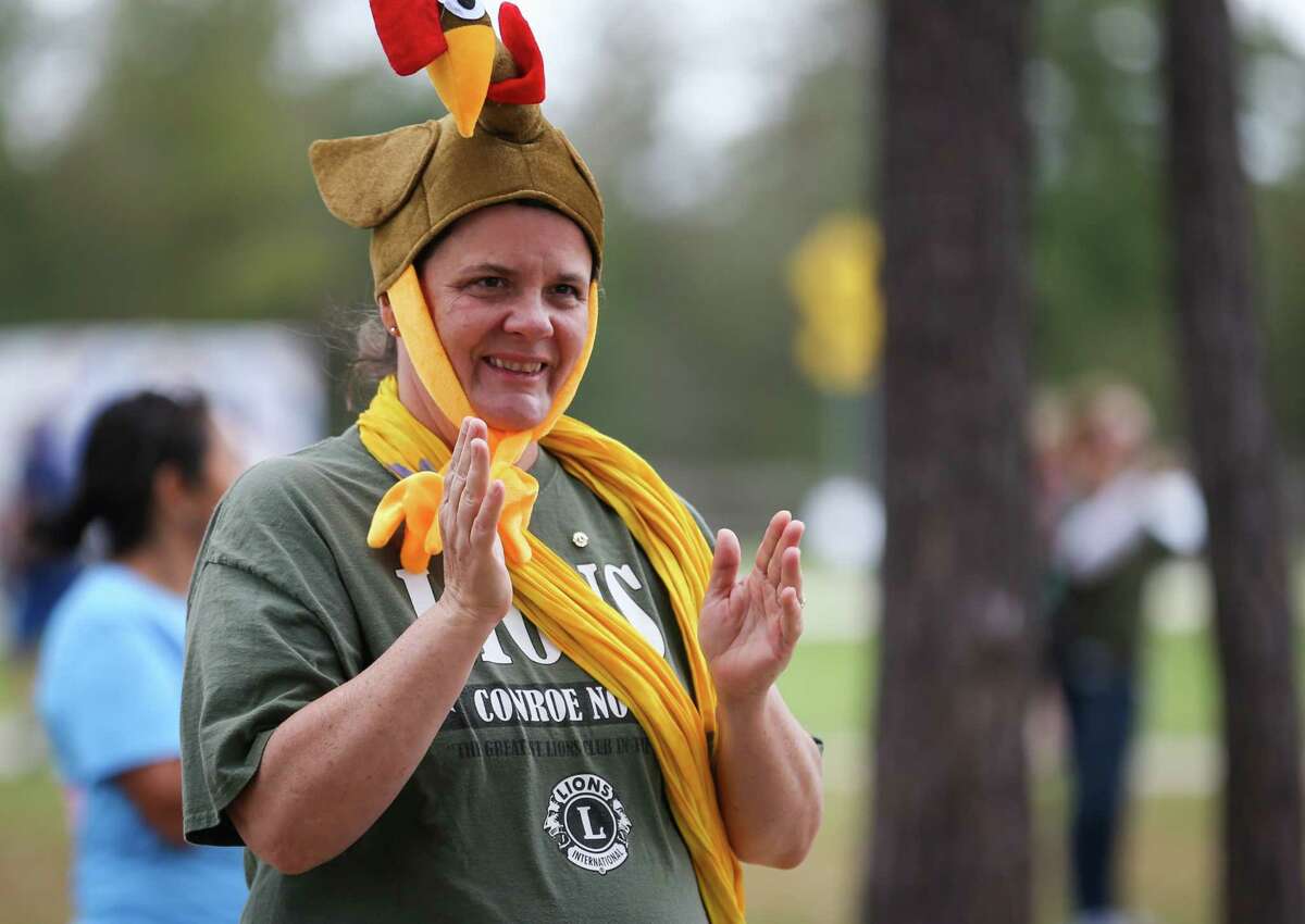 Shelia Thomas, a Conroe Noon Lions Club volunteer, cheers on runners during the Turkey Trot event on Friday, Nov. 17, 2017, at Carl Barton Jr. Park.