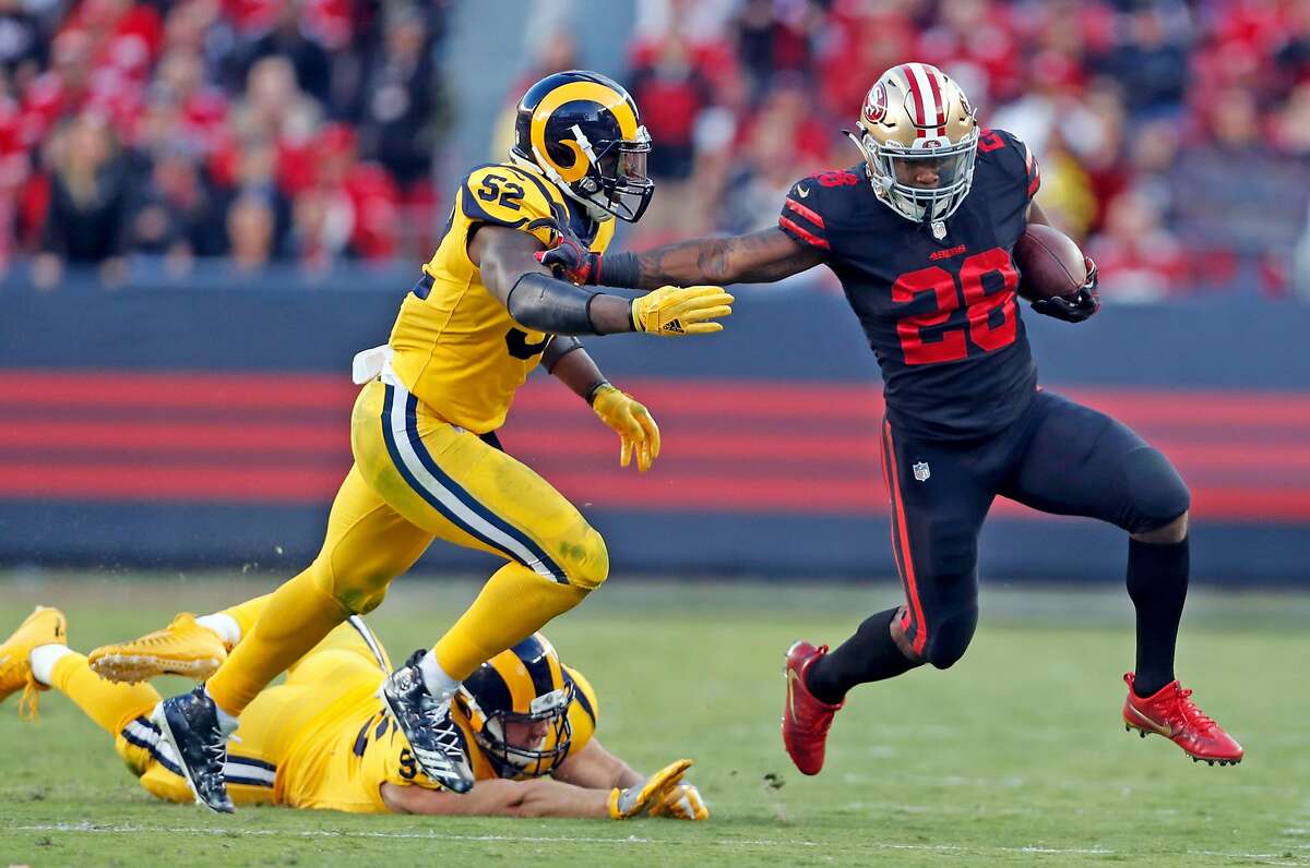 San Francisco 49ers' Carlos Hyde tries to stiff arm Los Angeles Rams' Alec Ogletree in 2nd quarter during NFL game at Levi's Stadium in Santa Clara, Calif., on Thursday, September 21, 2017.