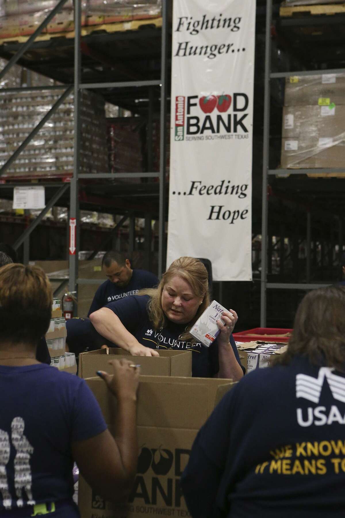 Volunteers from USAA pack boxes of food for seniors Nov. 3 at the San Antonio Food Bank. The Food Bank serves 16 counties in the San Antonio area.