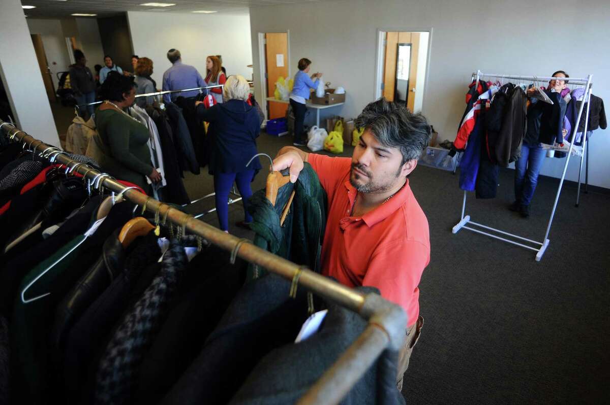 Volunteer Chris Prieto hangs coats on a hanger for clients to choose from during the Schoke Jewish Family Service of Fairfield County's coat and turkey drive on Summer Street in downtown Stamford, Conn. on Tuesday, Nov. 21, 2017.