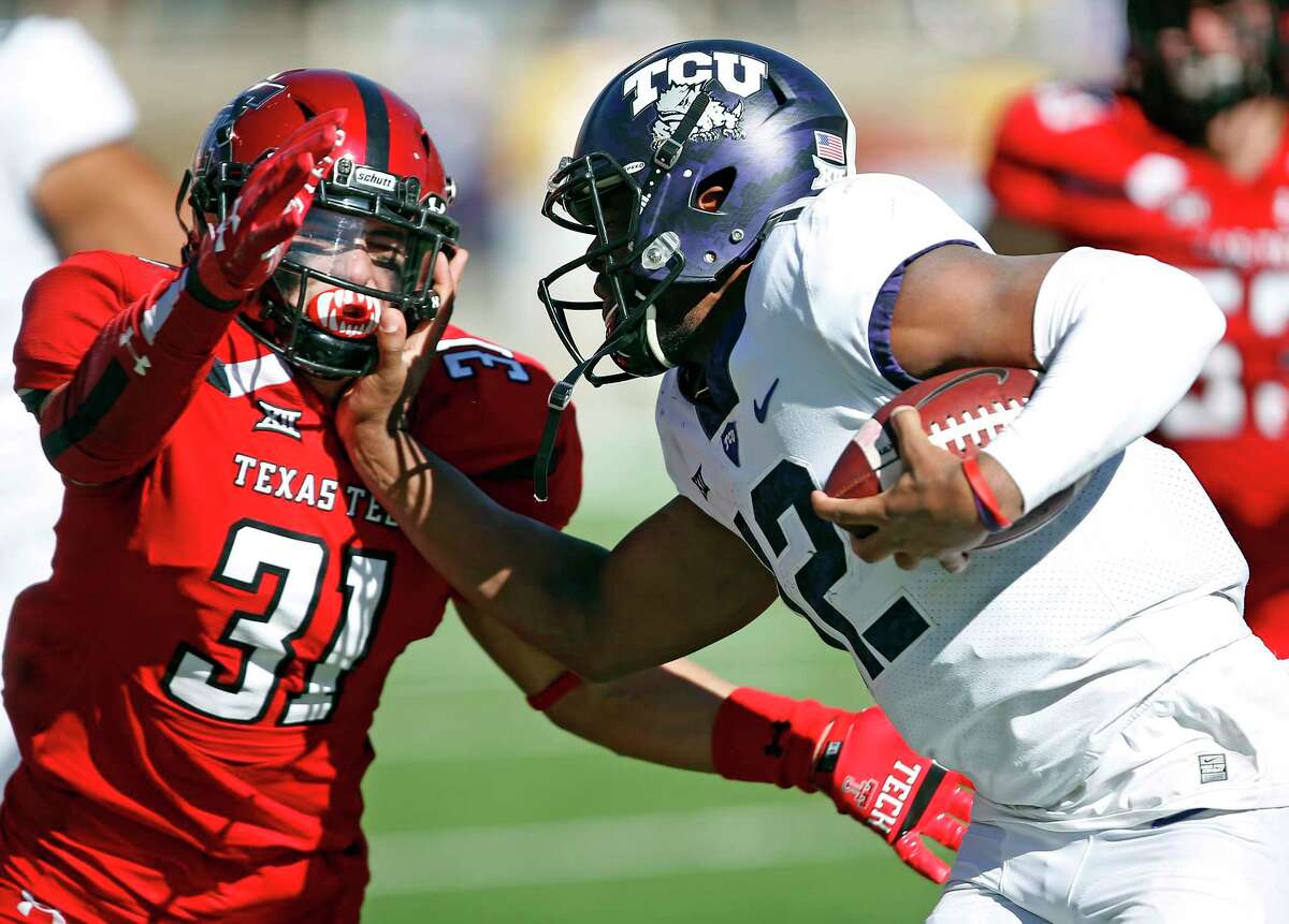 FILE - In this Saturday, Nov. 18, 2017, file photo, TCU's Shawn Robinson (12) tries to run around Texas Tech's Justus Parker (31) during the second half of an NCAA college football game in Lubbock, Texas. quarterback to step up as the regular season winds down. For the Horned Frogs, Shawn Robinson became the first true freshman quarterback to start for coach Gary Patterson in his 17 seasons as the head coach in last weekÂs 27-3 win over Texas Tech. (AP Photo/Brad Tollefson, File)