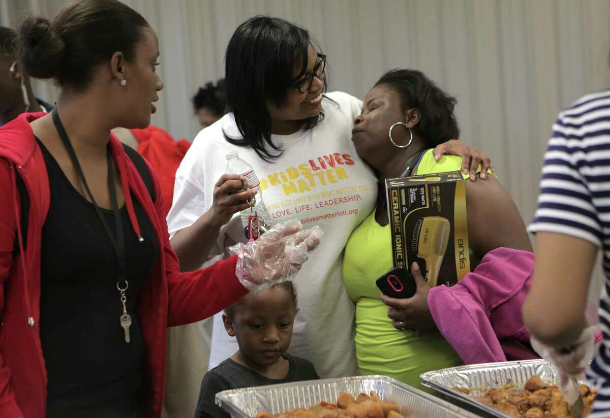 Kids Lives Matter executive director Catherine Smith, hugs an attendee of their annual Thanksgiving community outreach event for more than 1,500 less fortunate children and families at Cuney Homes Apartments on Wednesday, Nov. 22, 2017, in Houston. ( Elizabeth Conley / Houston Chronicle )