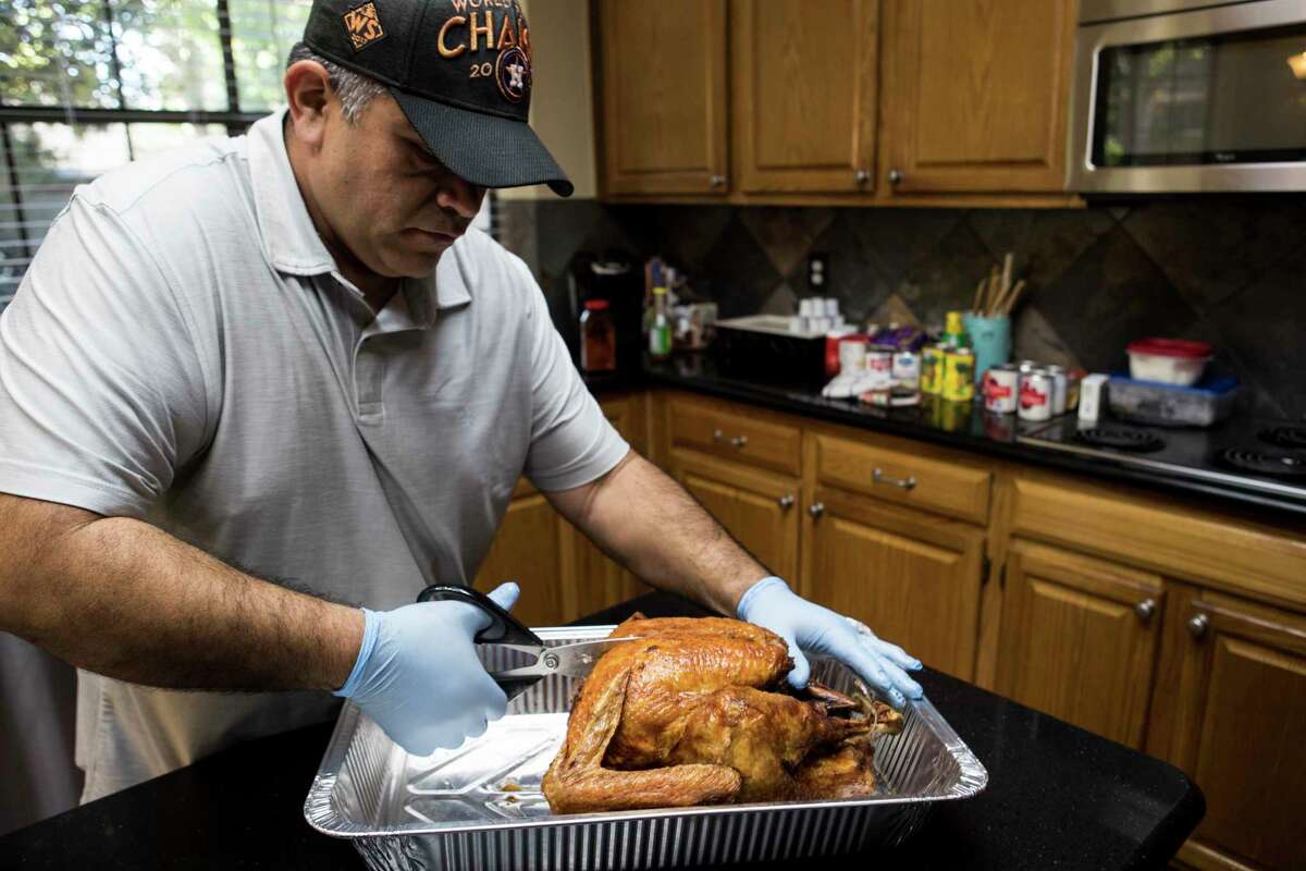 Colombo Forero cuts up a fried turkey while preparing a Thanksgiving meal for victims of Hurricane Harvey, at his home, on Monday, Nov. 20, 2017, in Friendswood. Forero will and his wife will take Thanksgving meals to about 200 people displaced by the storm now living in hotels since the storm. ( Brett Coomer / Houston Chronicle )