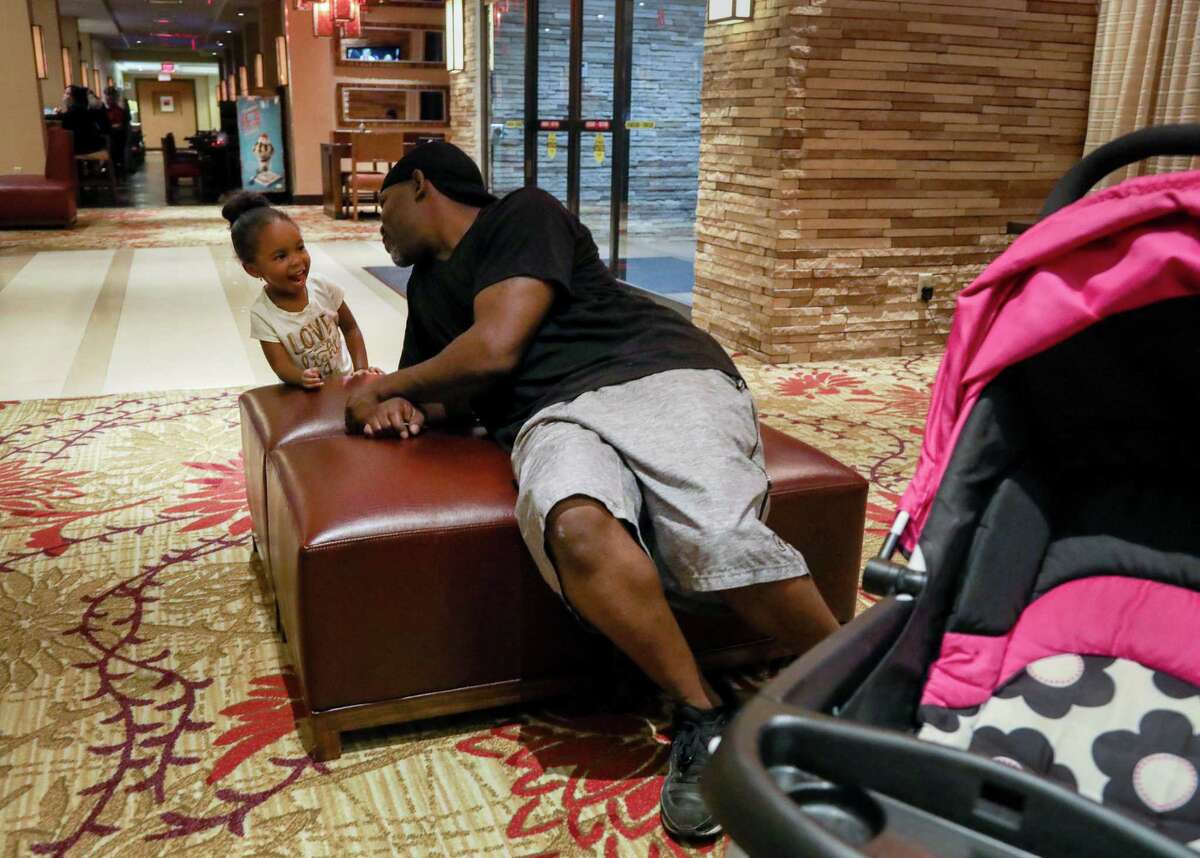 Mikey Robinson, left, talks to his girlfriend's daughter, Nori Nolan, 3, in the lobby of a hotel in the Greenspoint area, Wednesday, Nov. 15, 2017, in Houston. ( Jon Shapley / Houston Chronicle )