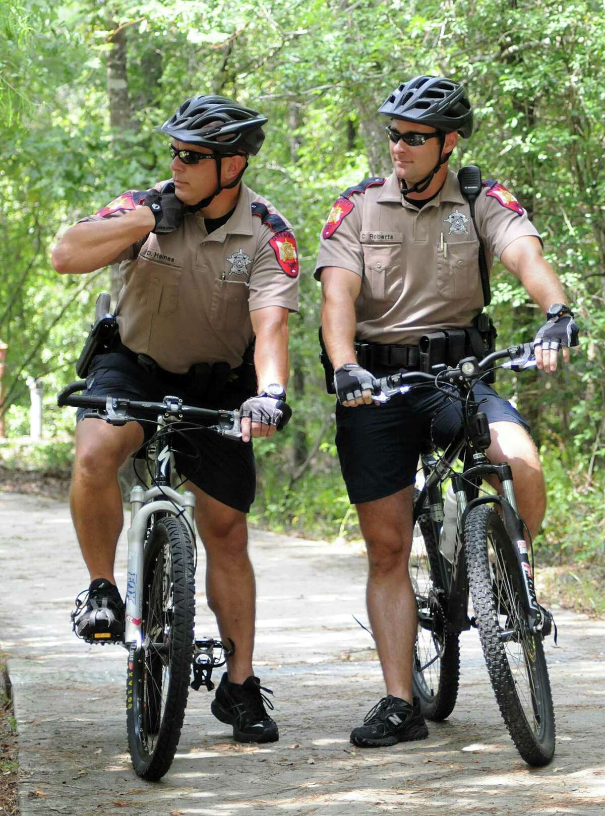Montgomery County Sheriff's Department Bike Patrol deputies David Haines and Chris Roberts call in a suspicious vehicle license as they ride a patrol on one of the bike paths in The Woodlands. The bike patrols have started more patrols into residential neighborhoods following recent assaults on the bike paths. Photo by David Hopper.