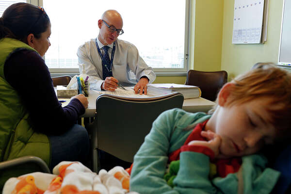 Carrie meets with Dr. K. Scott Baker about plans for Rowan's transplant as Rowan sleeps at Seattle Cancer Care Alliance in Seattle on Nov. 6, 2015. Baker is director of the Fred Hutchinson Cancer Research Center Survivorship Program and is the director of the Pediatric Blood and Marrow Transplant program. He works with pediatric bone marrow transplantation patients at Seattle Cancer Care Alliance and Seattle Children's Hospital.