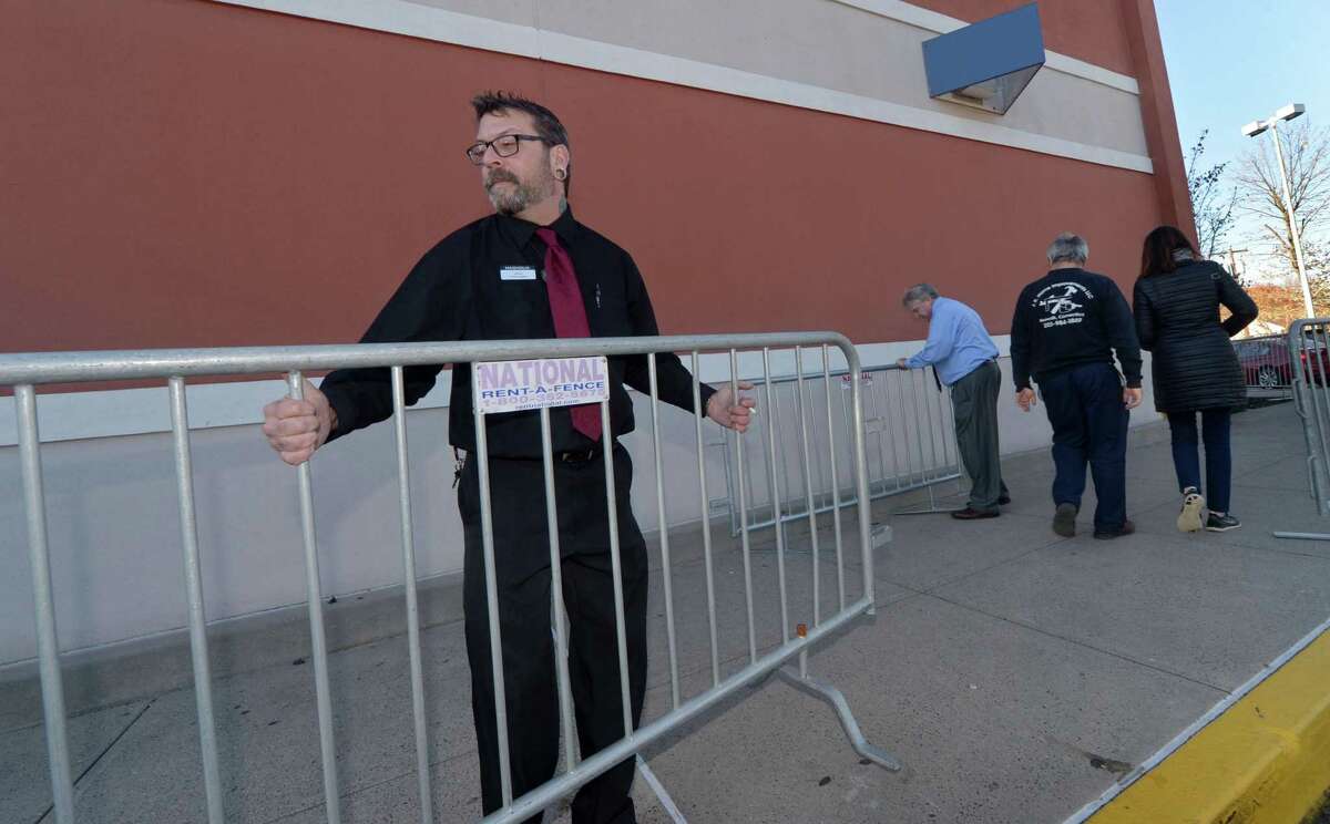 Systems Designer for Magnolia at Best Buy, Tommie Coney, removes barricades on Black Friday, November 24, 2017, in Norwalk, Conn.