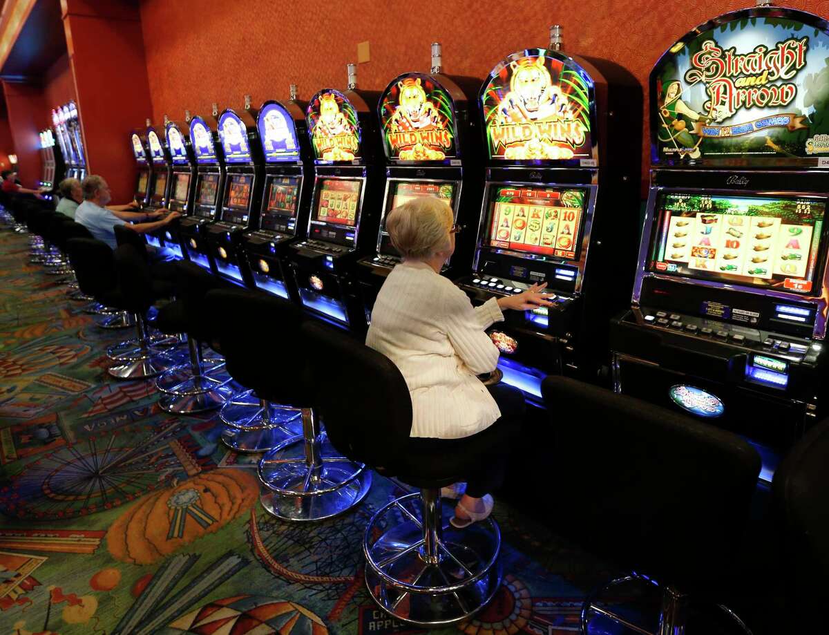 This photo from Thursday, Oct. 16, 2014 show individuals playing video lottery terminals at Tioga Downs, in Nichols, N.Y. The New York inspector general recently uncovered two schemes to dodge state contracting rules involving Tioga Downs. (AP Photo/Mike Groll, File)