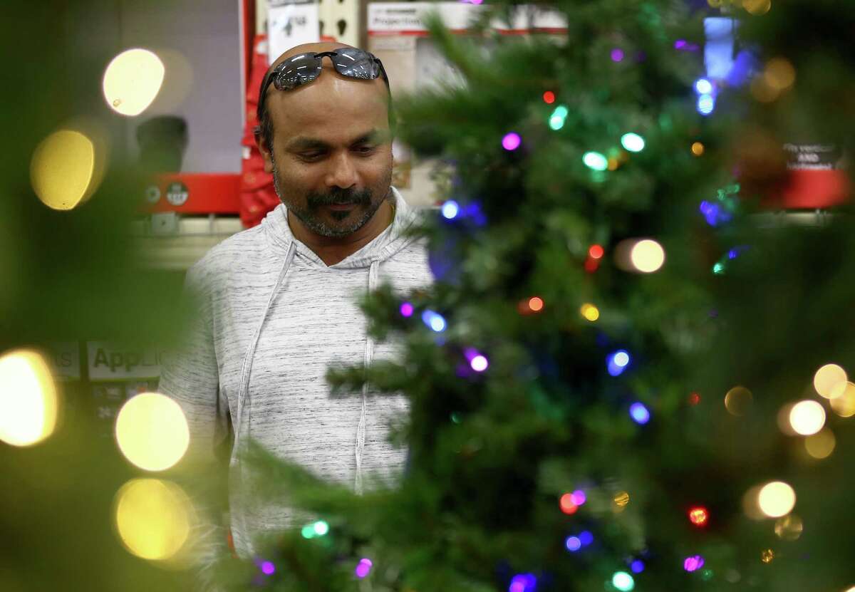 Vinesh Viswanathan looks over Christmas trees on Black Friday at the Home Depot in Webster.