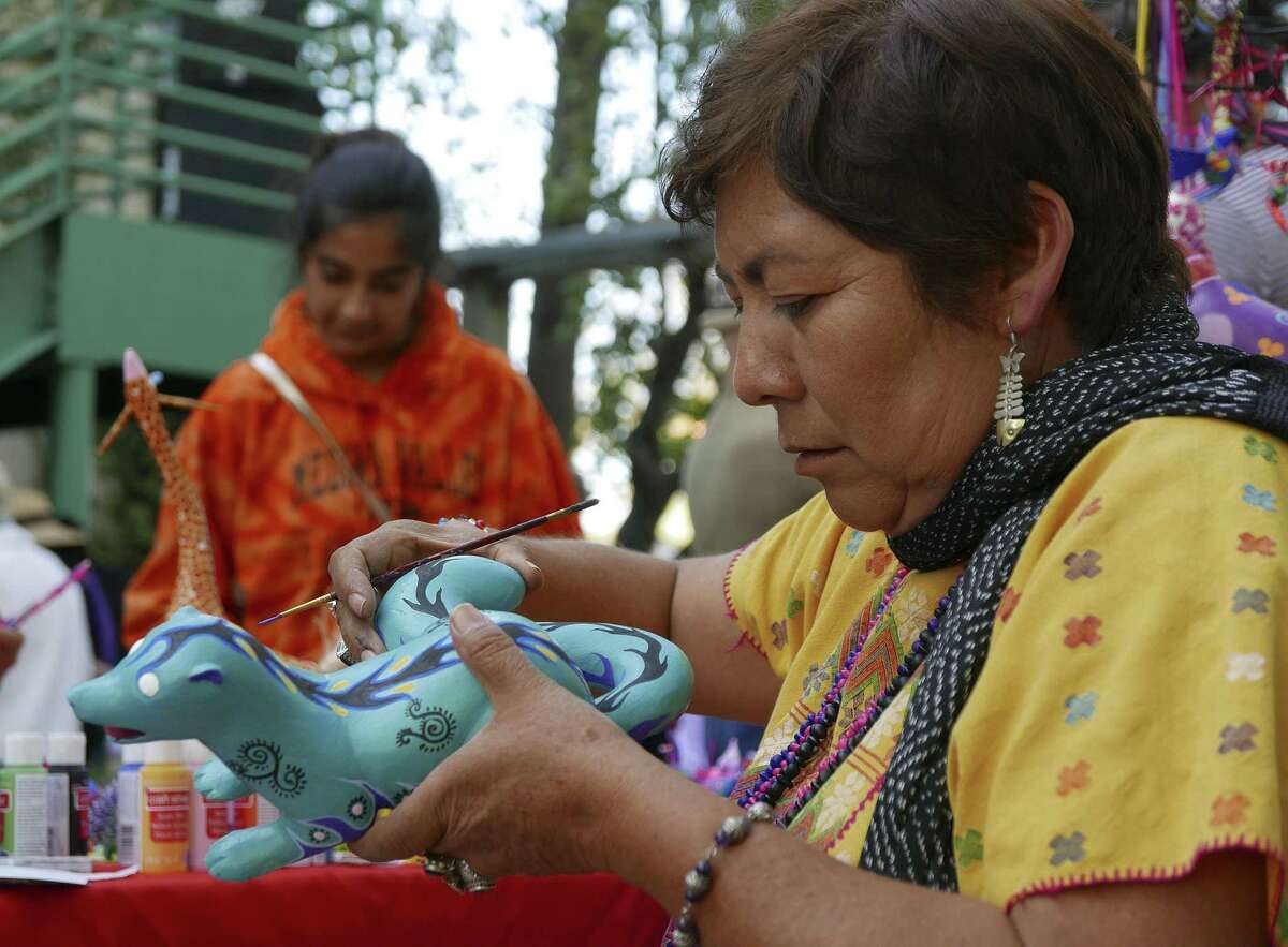 Cristina Antonio Herrera, who is from the municipality of Arrazolaxoxo in the Mexican state of Oaxaca, paints an alebrije, a kind of fantasy creature, at the annual International Peace Market at the Esperanza Peace and Justice Center on Saturday, Nov. 25, 2017. The event is in its 28th year. It combines arts and social consciousness economic sustainability. It is touted as a place to buy unique Christmas gifts. Herrera's home was damaged in a recent earthquake.