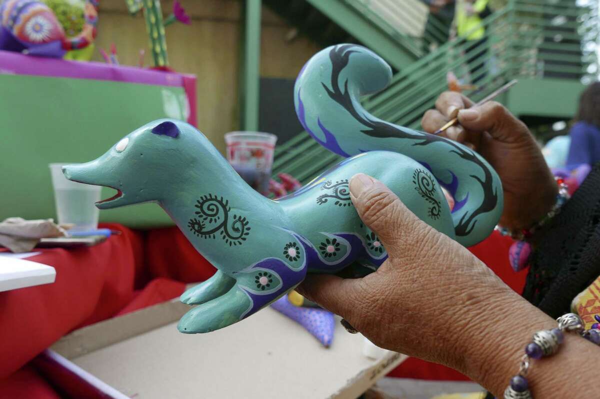 Cristina Antonio Herrera, who is from the municipality of Arrazolaxoxo in the Mexican state of Oaxaca, paints an alebrije, a kind of fantasy creature, at the annual International Peace Market at the Esperanza Peace and Justice Center on Saturday, Nov. 25, 2017. The event is in its 28th year. It combines arts and social consciousness economic sustainability. It is touted as a place to buy unique Christmas gifts. Herrera's home was damaged in a recent earthquake.